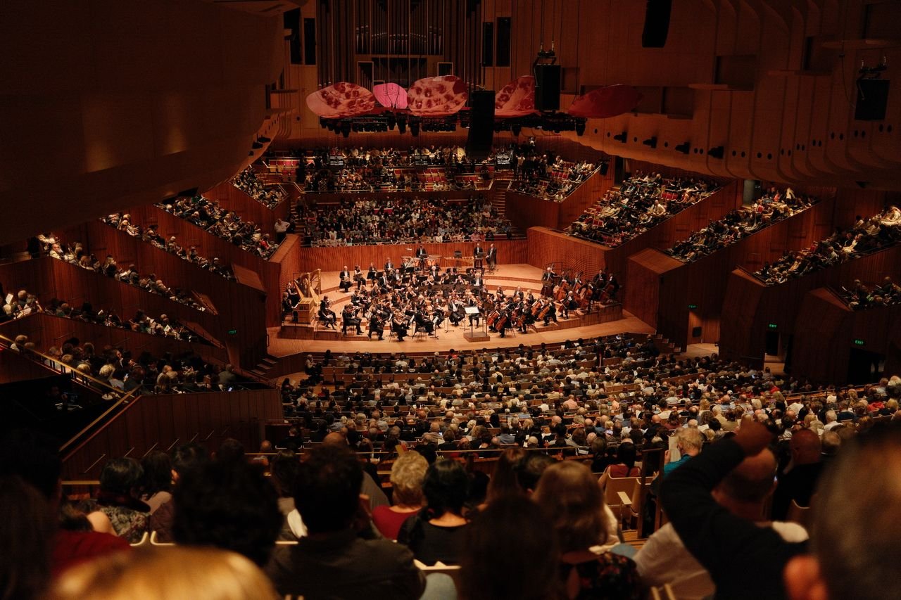 Audience watching an opera performance inside a grand opera house.